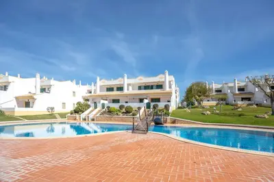 a villa with a swimming pool in front of a house at Summer Villa in Albufeira