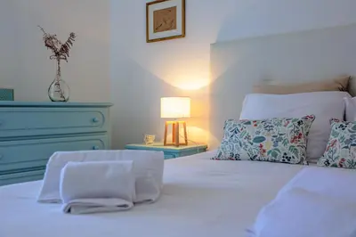 a bedroom with a white bed with a blue dresser at Apartment Sandi in Albufeira