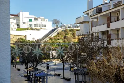 a street with benches and trees in a city at Apartment Sandi in Albufeira