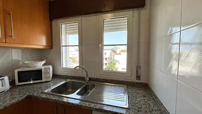 a kitchen with a sink and a microwave at La vie simple appartement in Albufeira