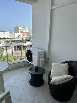 a room with a tv and a chair and a window at La vie simple appartement in Albufeira