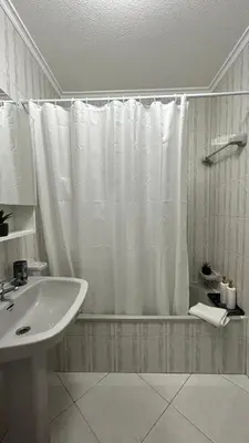 a bathroom with a shower curtain and a sink at La vie simple appartement in Albufeira