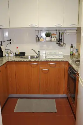 a kitchen with wooden cabinets and a sink at Recanto de Férias in Albufeira