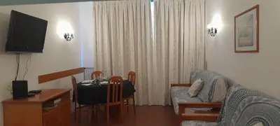 a living room with a table and a couch and a television at Recanto de Férias in Albufeira
