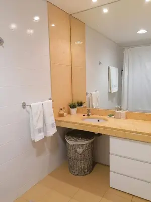 a bathroom with a sink and a large mirror at Recanto de Férias in Albufeira