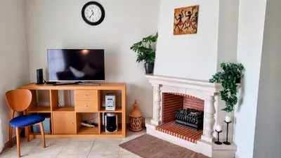 a living room with a fireplace and a tv at Casa ARRIFES in Albufeira