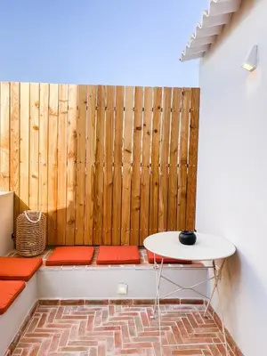 a room with a bench with a table and a wall at Casa Melro in Faro