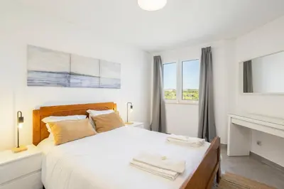 a bedroom with a white bed with two towels on it at TAC - Bliss Vilamoura in Quarteira