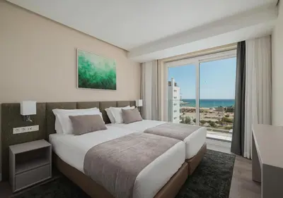 a bedroom with a large bed and a large window at Dom Pedro Residences in Vilamoura
