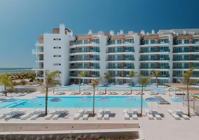 a large hotel with a pool and chairs and a building at Dom Pedro Residences in Vilamoura