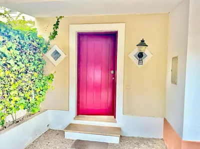 a pink door on the side of a house at Heart of Quinta do Lago ! in Faro