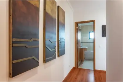 a hallway with three shelves on a wall with a bathroom at Blife RYA private rooms - Airport stay in Faro