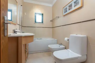 a bathroom with a toilet and a sink and a tub at Blife RYA private rooms - Airport stay in Faro