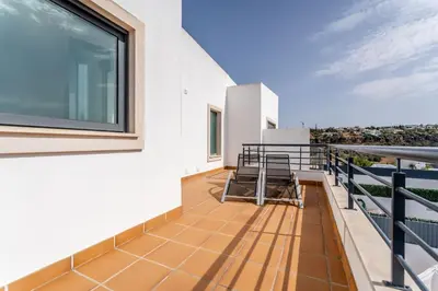 a balcony with chairs and a large window at Villa Feliz Algarve with Private Pool - São Rafael in Albufeira