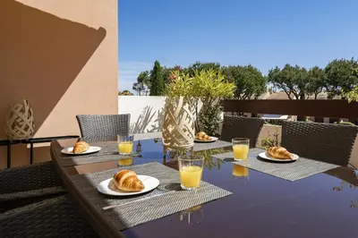 a table with plates of croissants and glasses of orange juice at BmyGuest - Vilamoura Vila Sol Golf II in Vilamoura