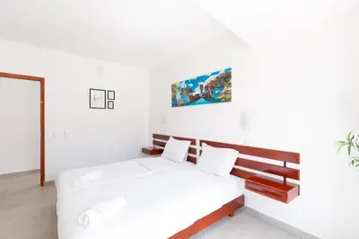 a white bedroom with a large white bed in it at Villa Eskape in Albufeira