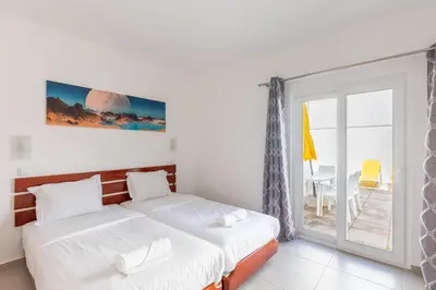 a bedroom with two beds and a sliding glass door at Villa Eskape in Albufeira