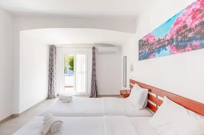 a bedroom with two beds and a painting on the wall at Villa Eskape in Albufeira
