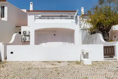 a white house with a white fence and a bench at Villa Eskape in Albufeira