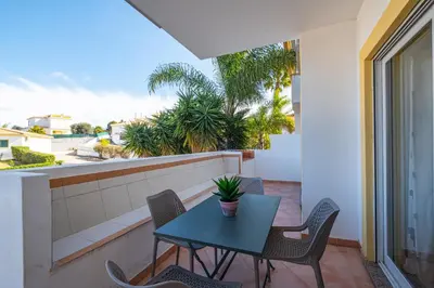 a patio with a table and chairs on a balcony at Farmvillage Apartment - Free Wifi in Albufeira