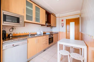 a kitchen with wooden cabinets and a white counter top at Farmvillage Apartment - Free Wifi in Albufeira