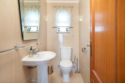 a bathroom with a toilet and a sink and a mirror at Villa Magdalena in Albufeira
