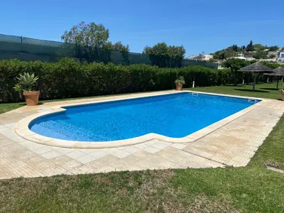 a large blue swimming pool in a yard at Villa Magdalena in Albufeira
