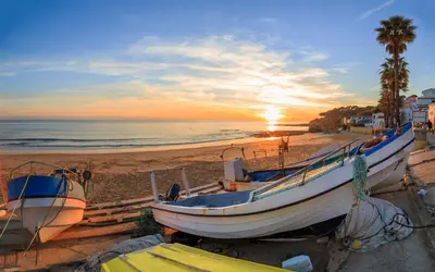 a group of boats on the beach at sunset at Villa Magdalena in Albufeira