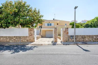 a house with a garage and a fence at Villa Pinheiro in Albufeira