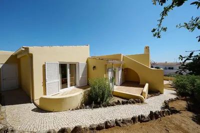 a small yellow house with a yard at Villa Pinheiro in Albufeira