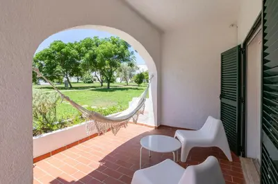 a porch with a hammock and a table and chairs at Centralgarve - Excellent & Peaceful Villa in the Center of Vilamoura in Vilamoura
