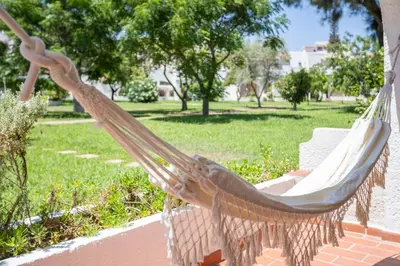 a hammock on a porch in a park at Centralgarve - Excellent & Peaceful Villa in the Center of Vilamoura in Vilamoura
