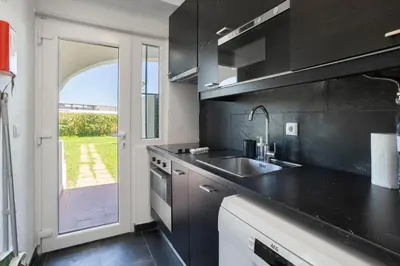 a kitchen with black counters and a sink and a window at Centralgarve - Excellent & Peaceful Villa in the Center of Vilamoura in Vilamoura