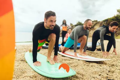 a group of people on a surfboard in the water at #212 Vila Magna 106B by Home Holidays in Albufeira