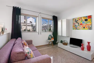 a living room with a purple couch and a tv at Casa da Saudade no centro de Faro in Faro