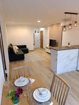 a living room with a table and chairs and a kitchen at Albufeira - Sun, Pool and Marina View! in Albufeira