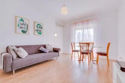 a living room with a couch and a table and chairs at Spacious 2 bedroom apartment in Faro in Faro