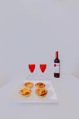 a white table with three glasses and a bottle of wine at Spacious 2 bedroom apartment in Faro in Faro