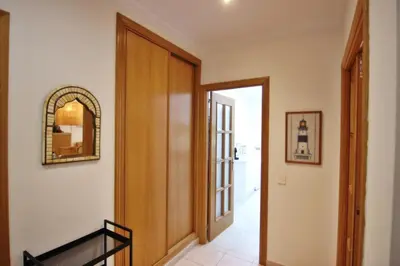 a hallway with a wooden door and a mirror at Los Arcos 3 - Pool & Vilamoura Center in Vilamoura