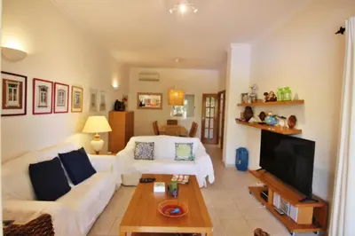 a living room with a white couch and a tv at Los Arcos 3 - Pool & Vilamoura Center in Vilamoura