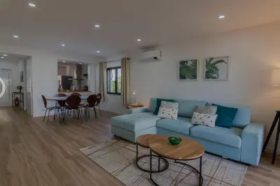 a living room with a blue couch and a table at Beachside Bliss T2 with Pool & Beach Access by Drago Rentals in Albufeira