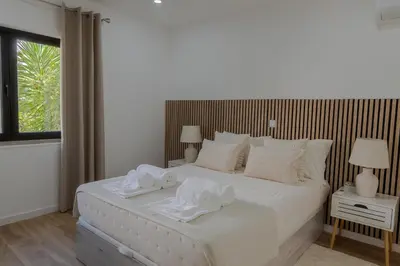 a bedroom with a large white bed with towels on it at Beachside Bliss T2 with Pool & Beach Access by Drago Rentals in Albufeira