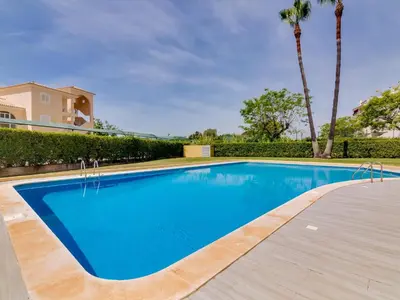 a swimming pool in a villa with palm trees at AL - Apartamento Novo Horizonte in Vilamoura