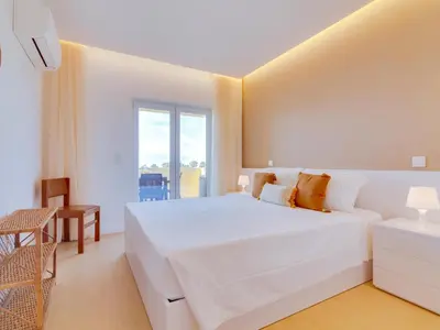 a white bedroom with a large bed and a window at AL - Apartamento Novo Horizonte in Vilamoura