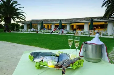 a table with a plate of food and two glasses of wine at Balaia Golf Village apt 105 in Albufeira