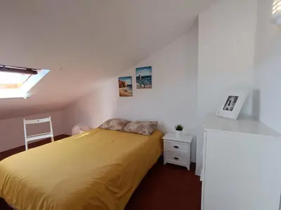 a bedroom with a bed with a yellow bedspread at Apartamento Praia da Gale in Albufeira