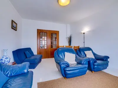 a living room with two blue chairs and a couch at Central 2bdr apartment in Quarteira in Quarteira