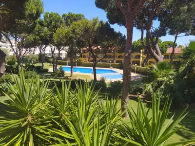 a swimming pool in a park with trees and plants at SolNascenteII-Vilamoura in Quarteira