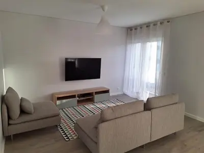 a living room with a couch and a flat screen tv at Apartment Center View in Faro