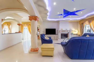 a living room with blue chairs and a star on the ceiling at Exceptional Villa with Pool, Tennis Court, Games Room in Quarteira
